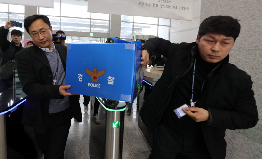 대전지방경찰청 직원들이 15일 폭발사고가 난 한화 대전공장에서 가져온 압수품을 들고 경찰청사 안으로 들어가고 있다. <연합뉴스>